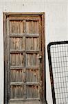 Vintage wooden door and rusty metal fence.