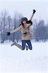 Young Jumping woman in snowy winter outdoors