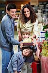 Happy family with boxes of gifts in shop