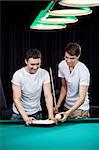 Two young men put spheres for billiards