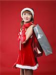 Portrait of a young charming girl dressed as Santa with a bag of shopping in their hands