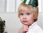 Child playing near to christmas fur-tree.