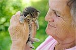 Senior woman holding little kitten