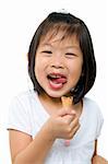 Little Asian girl licking her lips with an ice cream cone in hand.