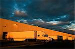 Dramatic sunset above distribution warehouse. Semi Truck ready to leave.