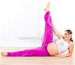 Smiling beautiful pregnant woman doing exercise  at home