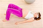 Smiling beautiful pregnant female doing fitness exercises at living room