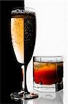 Glass of champagne and whisky with ice. A black and white background.