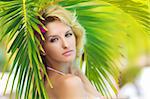 Portrait of a beautiful woman under palm tree