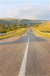 Old road led to mountains at summer daybreak.