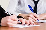 person's female hand signing an important document