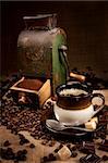 Old coffee mill and cup of coffee with chocolate