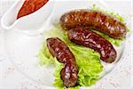 grilled sausage closeup with lettuce and red sauce