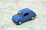 Tiny blue car model on the road map