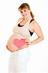 Smiling pregnant woman holding heart near her belly isolated on white