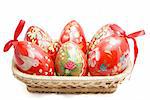 Hand painted Easter eggs in wicker basket isolated on white background