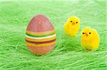 chicks and Painted Colorful Easter Egg on green Grass