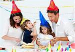 Beautiful mom serving a birthday cake to her family in the kitchen