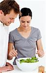Cute couple preparing a salad together in the kitchen