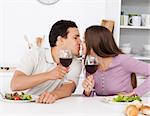 Cute couple giving a toast while having lunch in the kitchen