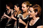Four clarinetist women musical performance. Side view