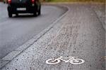 Close up of bicycle sign on sidewalk with gravel, selctive focus