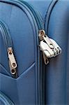 padlock with figures in modern suitcase close-up