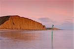 Golden sandstone cliffs at low tide, Burton Bradstock, Dorset, UK