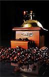 Coffee mill on the table with beans around