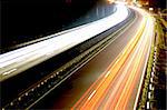 road with car traffic at night and blurry lights showing speed and motion