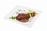 Beef steak on a white plate with vegetables on a white