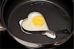 Fried egg on pan in iron form heart