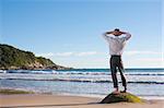 Businessman standing on a rock at the sea