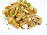 fried potatoes with pickled mushroom on white plate and is sprinkled by verdure and spice