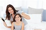 Woman brushing her daughter hair at home