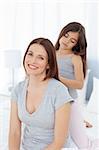 Lovely daughter brushing her woman hair at home