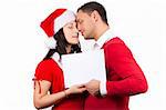 side view of tenderness young couple in red christmas clothes holding a white cardboard in hands