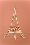 eiffel tower made of matches on red background