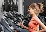 Young beautiful woman on exercise bicycle in fitness club