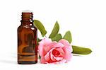 Bottles of essential oil and pink rose