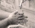 man washing hands outdoor in yard in black and white technique