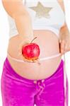 Pregnant woman measuring her belly and holding apple isolated on white. Close-up.