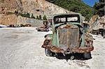 Rusty vintage car and industrial machinery at a quarry.