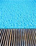 wood floor beside the blue swimming pool