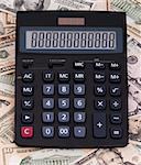 Calculator on money background of $5-$100 banknotes