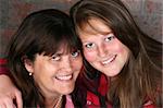 Beautiful mother and daughter against a brick-wall background