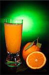 Natural orange juice in a glass and orange fruit, on black background shooting with green gel