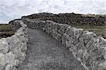 rocky walls and path against a cloudy scenic background in ireland