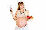 Pensive pregnant woman making choice between pills and fruits isolated on white