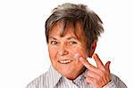 Senior woman applying lotion on her face isolated on white background